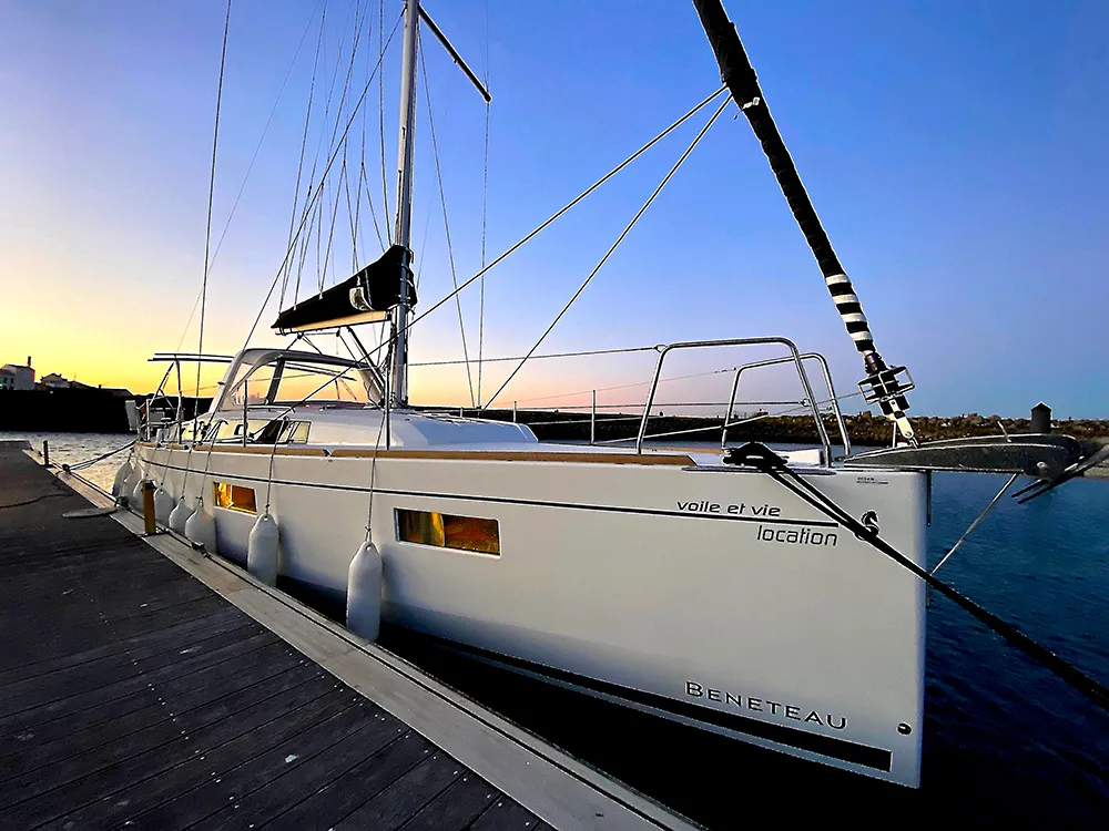 Un voilier Voile et Vie amarré au ponton au coucher du soleil